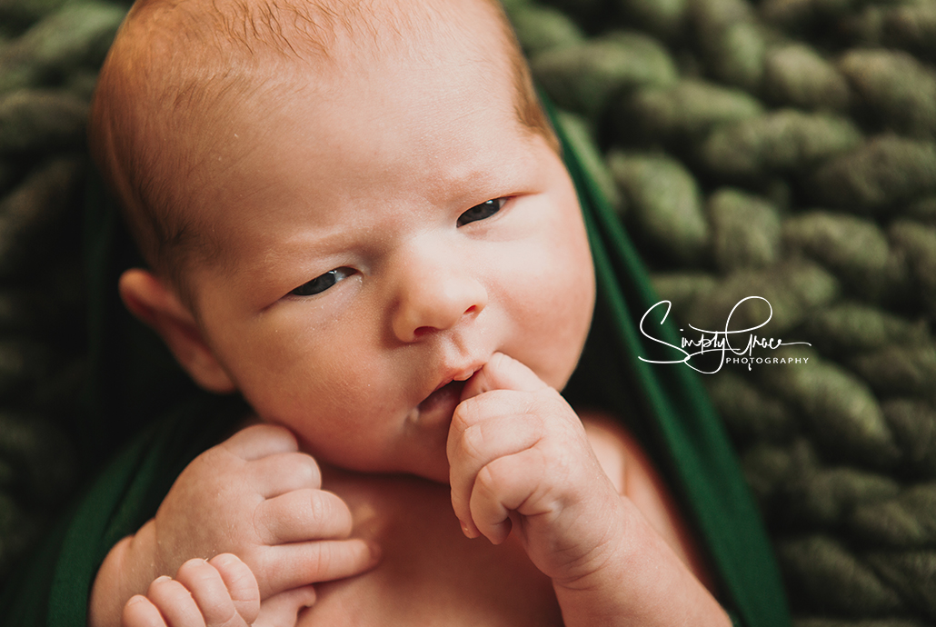 kansas city newborn photographer boy in green eyes open simply grace photography