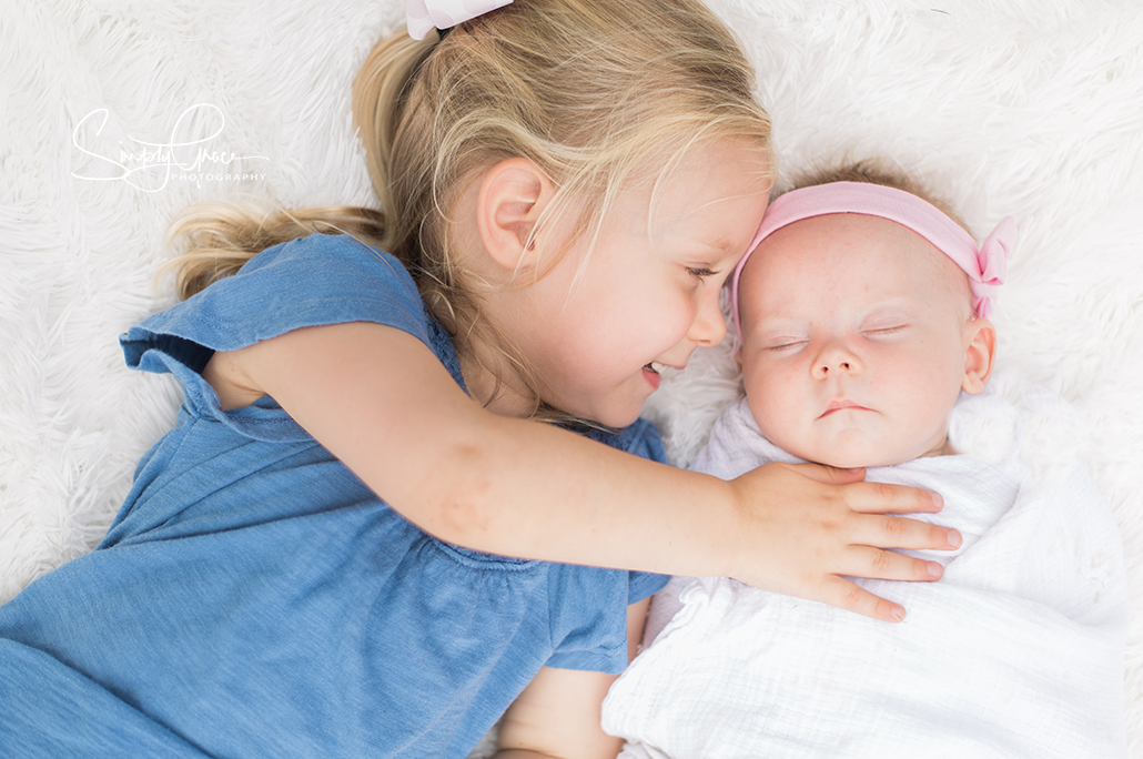 mission hills family session with simply grace photography sisters laying on blanket 4 month photo shoot