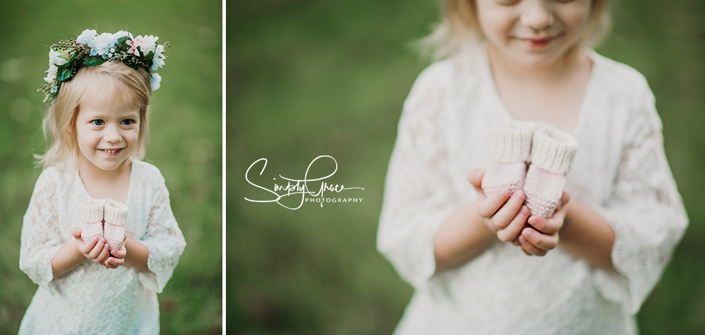 daughter holding baby booties at loose park simply grace phtoography