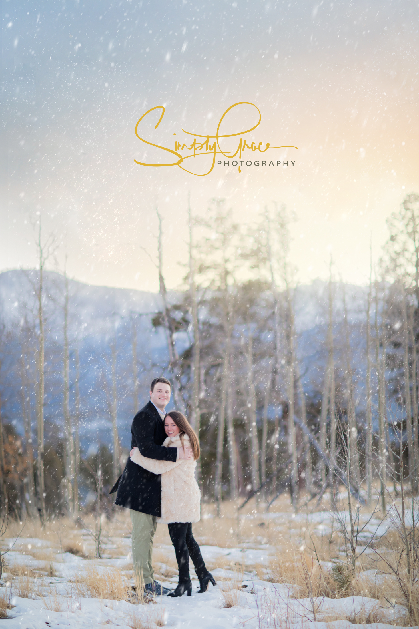 Engaged couple poses with snow falling in woodland park colorado