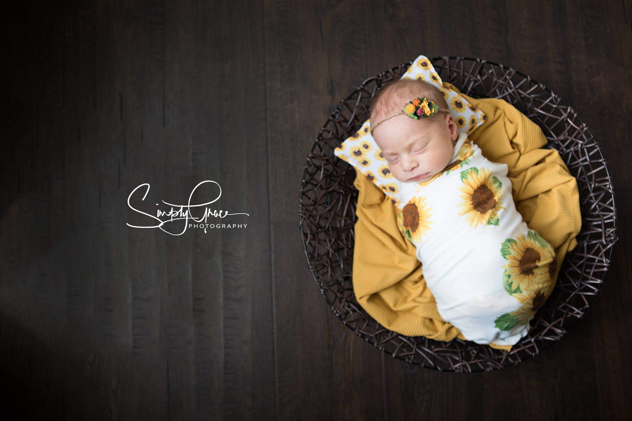 newborn girl in sunflowers and basket