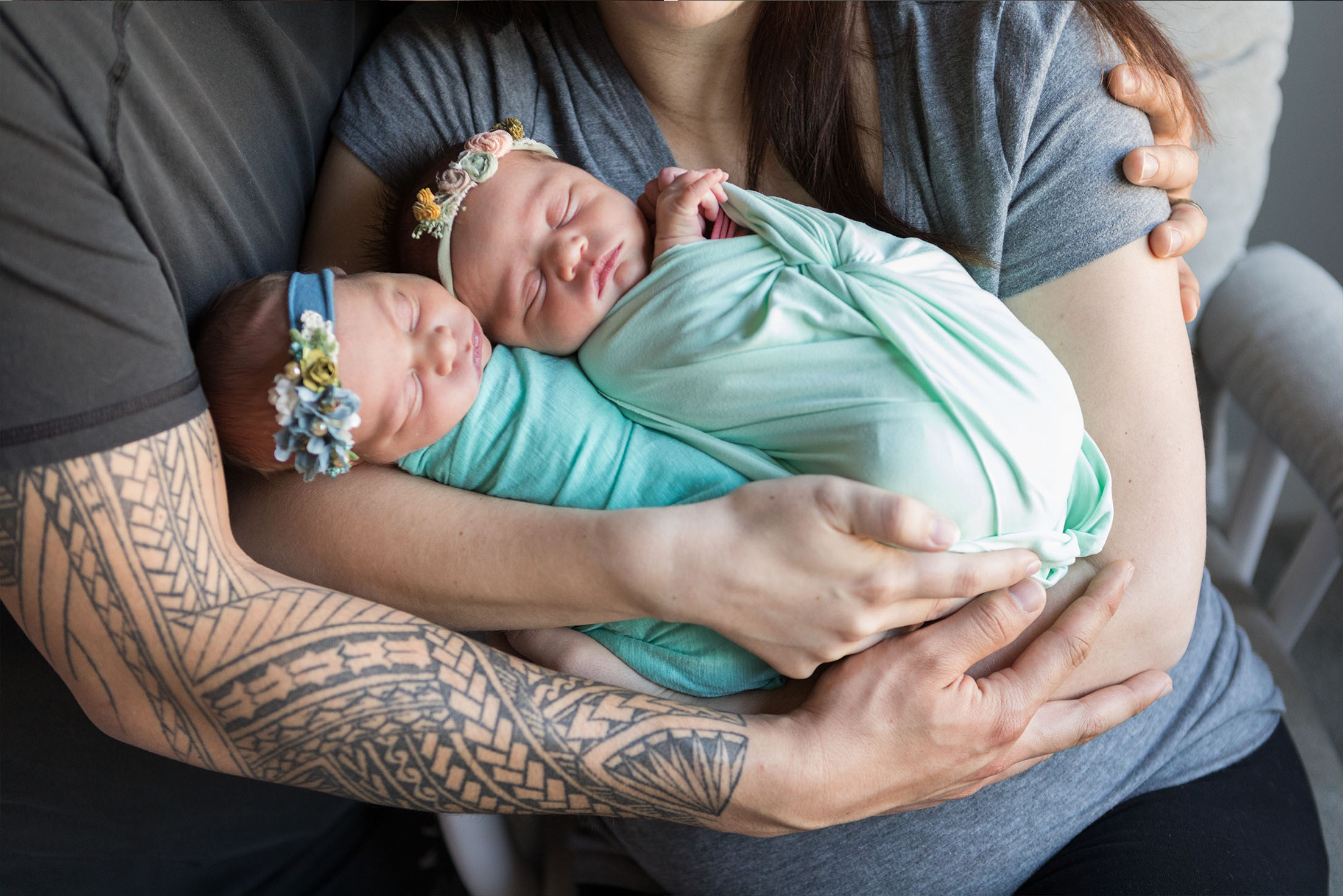 twin girls wrapped in both parent's arms