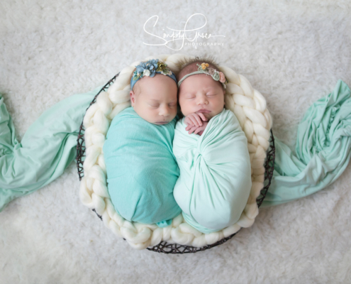 twins wrapped in teal in a basket