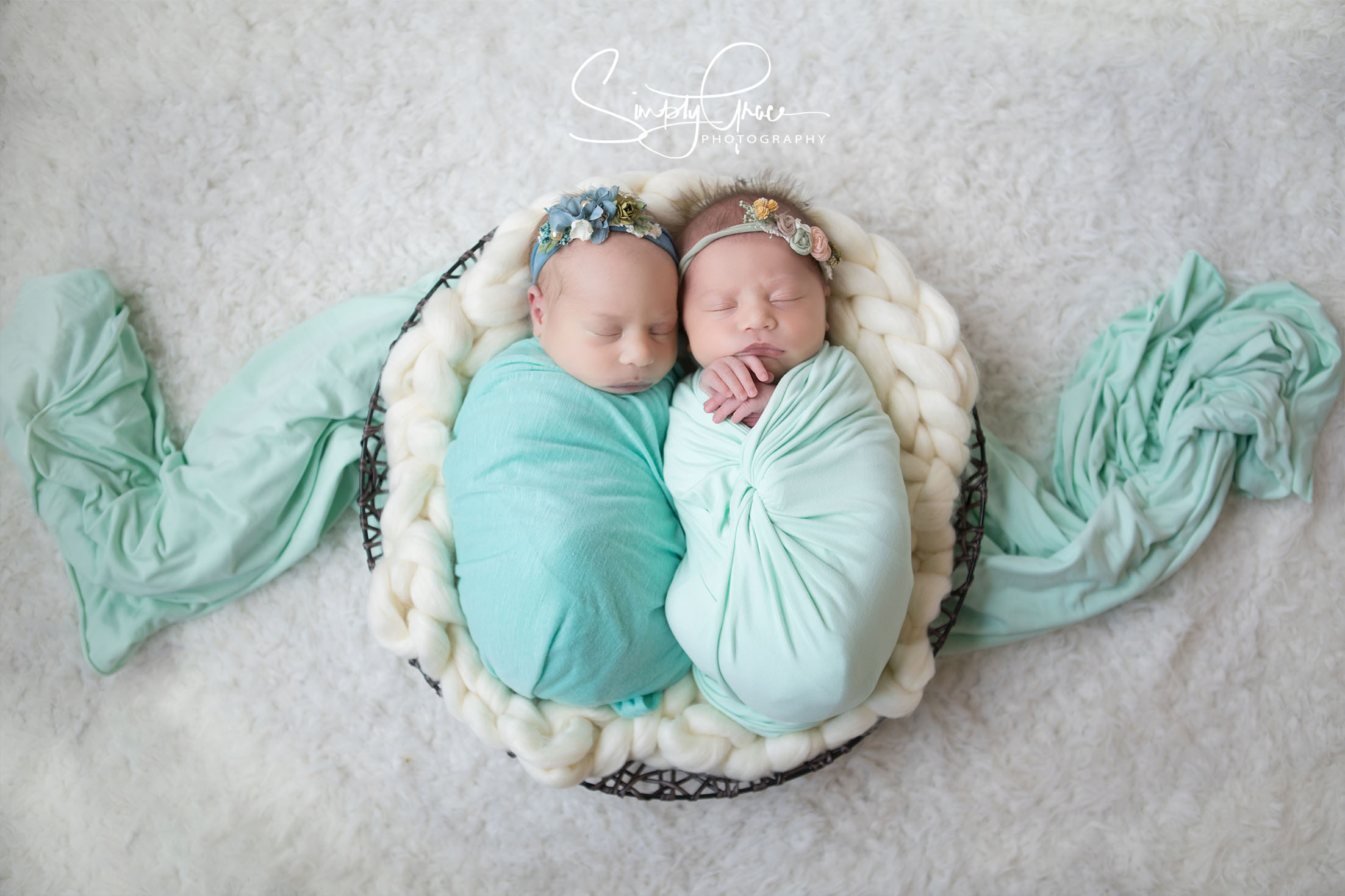 twins wrapped in teal in a basket