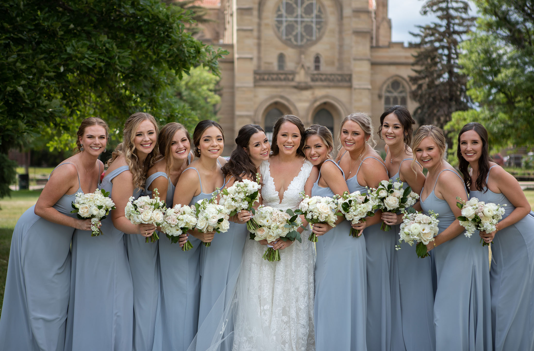 bridesmaids hug in dusty blue dresses