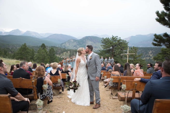 kiss after the wedding at the overlook chapel in estes park