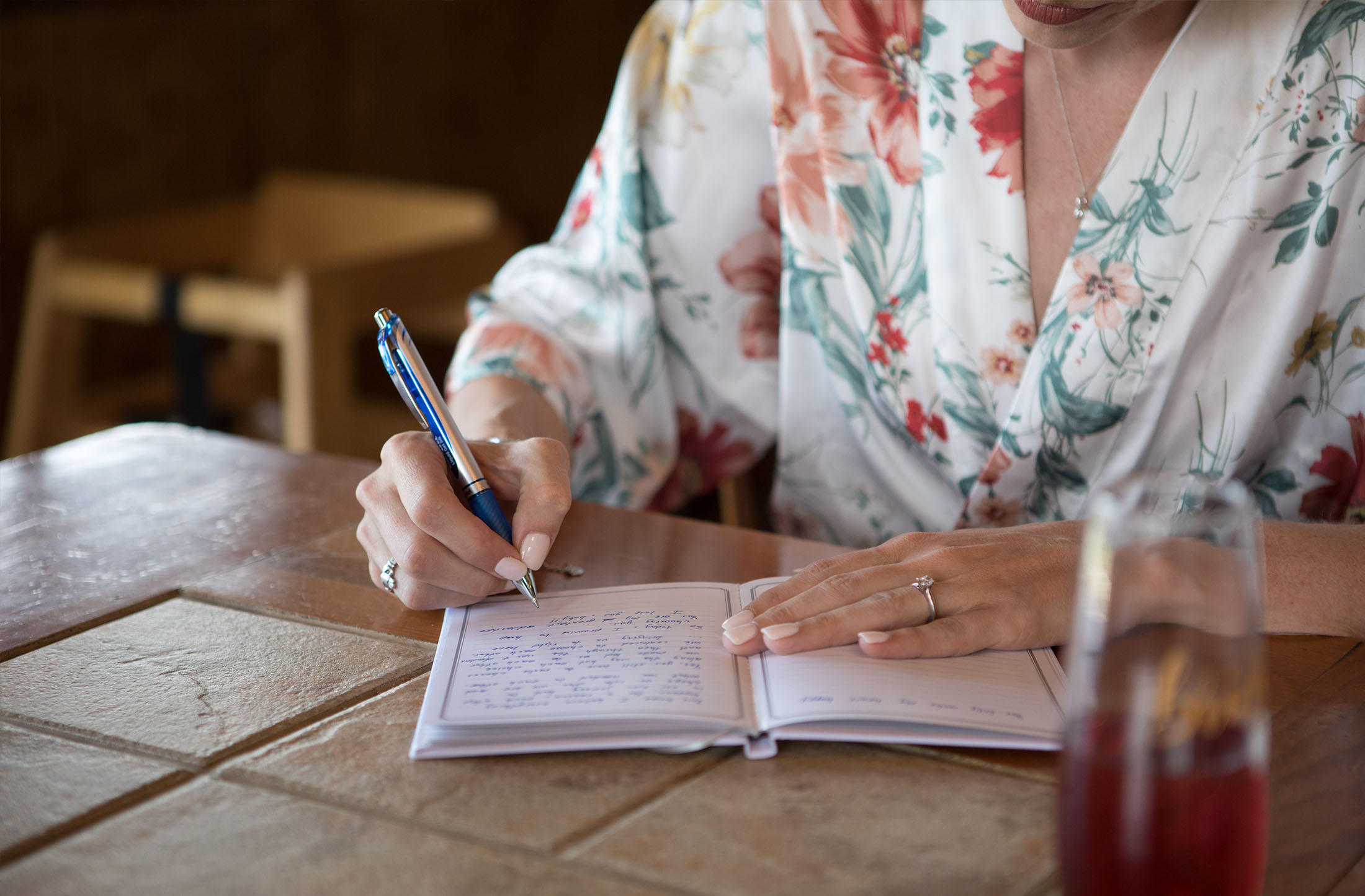 bride writing vows before her wedding in a floral robe