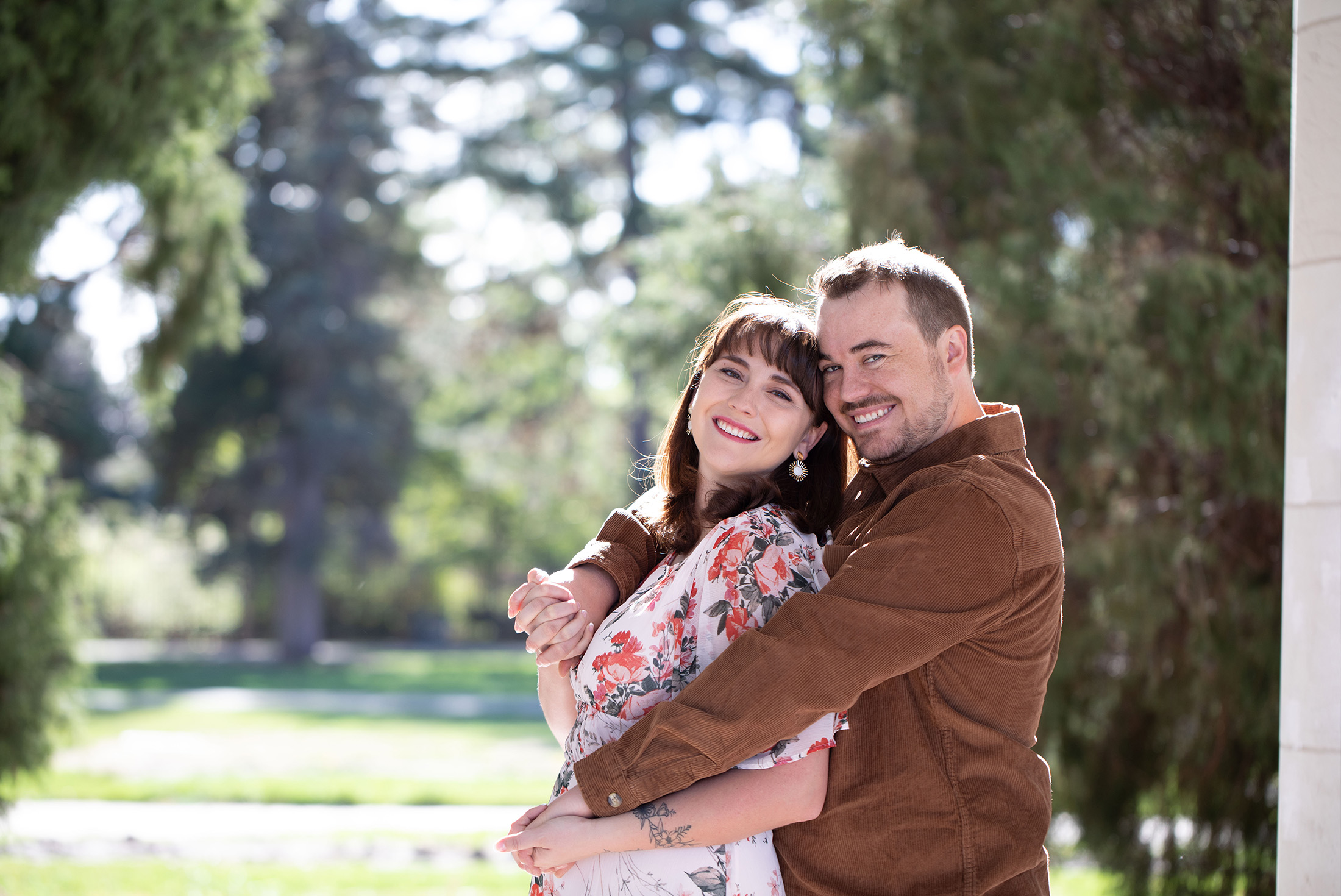 couple laughing with backlight during engagement session at cheeseman park