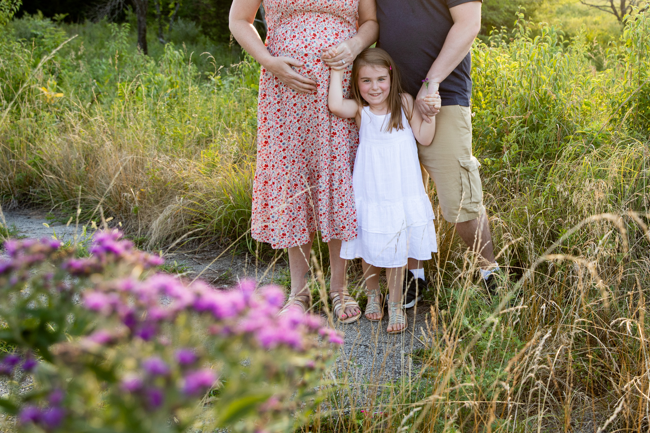 girl holding parents hands during lees summit maternity session