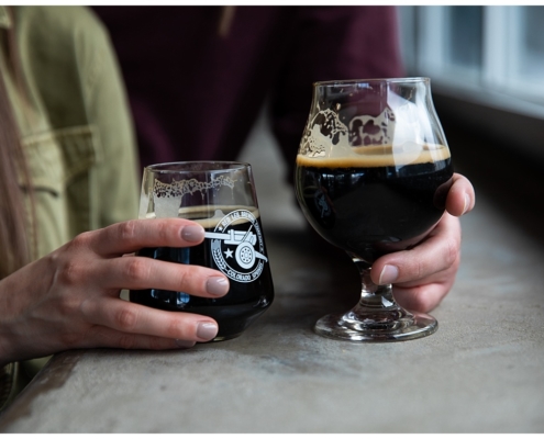 couple holding glasses of stout at red leg brewery