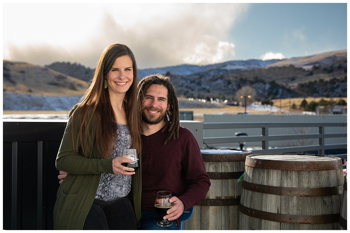 couple sitting on each others lap for an engagement session at red leg brewery