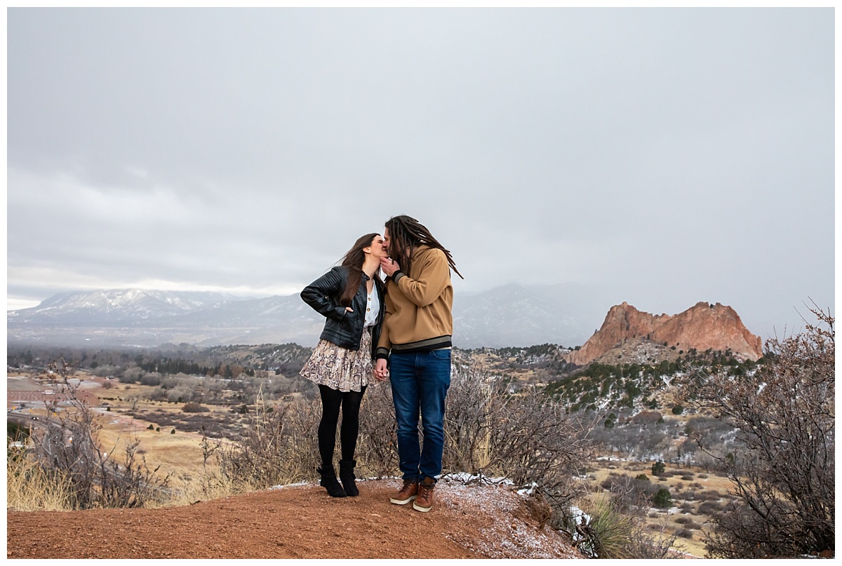 couple enjoying a kiss during their snowy session at garden of teh gods overlook