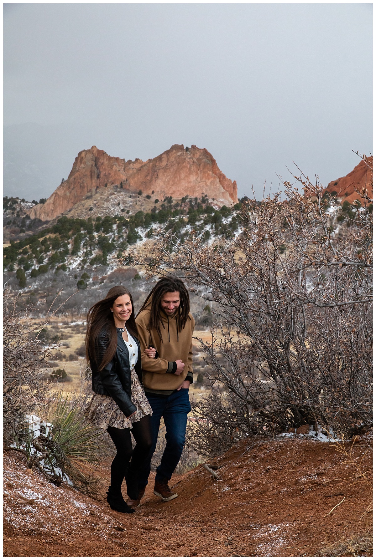 couple walking up the trail at garden of the gods overlook during their engagement session